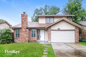 Houston house for rent - A house with a garage door and a brick chimney.