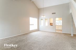 Houston house for rent - A spacious room with a carpeted floor and a staircase on the right side.