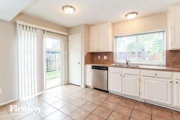 Houston house for rent - A kitchen with white cabinets and a tiled floor.