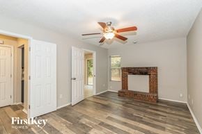 Jacksonville house for rent - a living room with a fireplace and a ceiling fan