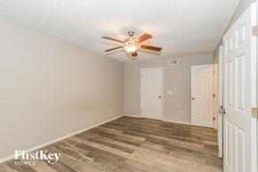 Jacksonville house for rent - a bedroom with a ceiling fan and a white door
