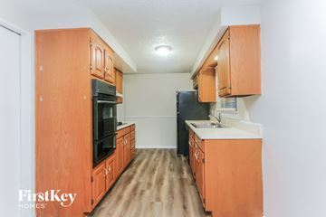 Indianapolis house for rent - A kitchen with wooden cabinets and a black refrigerator.