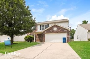 Fishers house for rent - A house with a garage and a tree in front of it.