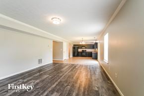Fishers house for rent - A spacious room with wooden flooring and a FirstKey Homes logo.
