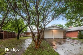 Garland house for rent - A tree in front of a house with a garage door.