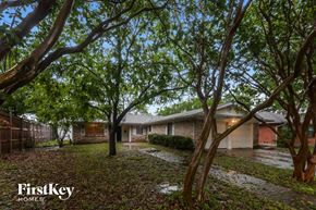 Garland house for rent - A tree-lined street with a house and a sign for FirstKey Homes.