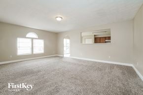 Blacklick house for rent - A spacious room with a carpeted floor and a large window.