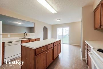 Blacklick house for rent - A kitchen with wooden cabinets and a white countertop.