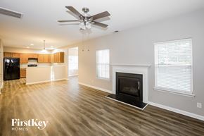 Charlotte house for rent - A spacious living room with a fireplace and a ceiling fan.