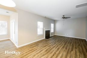 Charlotte house for rent - A spacious room with wood flooring and a ceiling fan.