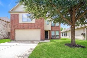 Houston house for rent - A red brick house with a tree in front.