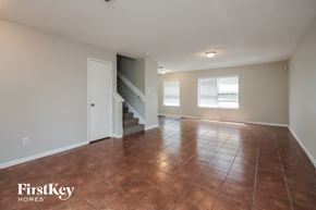 Houston house for rent - A room with a brown floor and a staircase leading to the second floor.