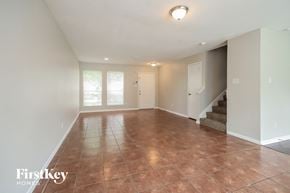 Houston house for rent - A spacious room with a staircase and a brown floor.