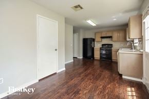Houston house for rent - A kitchen with wooden floors and a black fridge.