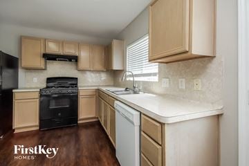 Houston house for rent - A kitchen with wooden cabinets and a black oven.