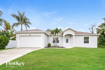 Englewood house for rent - a white house with a lawn and palm trees
