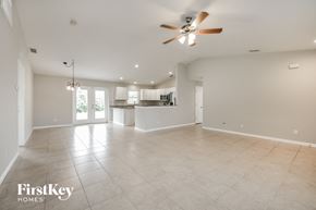 Englewood house for rent - an empty living room with a ceiling fan and a kitchen