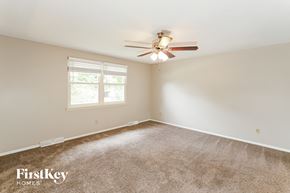 Liberty house for rent - A room with a carpeted floor, a ceiling fan, and a window with blinds.