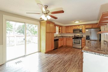 Liberty house for rent - A kitchen with wooden cabinets and a ceiling fan.