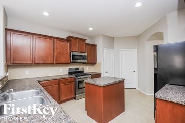 Melissa house for rent - a kitchen with granite counter tops and wooden cabinets