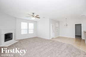 Melissa house for rent - a living room with a fireplace and a ceiling fan