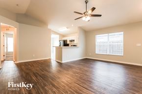 Riverview house for rent - an empty living room with a ceiling fan and a kitchen