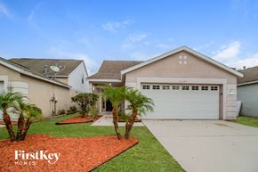 Riverview house for rent - a beige house with a white garage door and a lawn