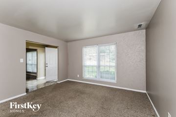 Saint Louis house for rent - a living room with carpet and a large window