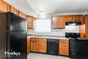 Saint Louis house for rent - a kitchen with black appliances and wooden cabinets