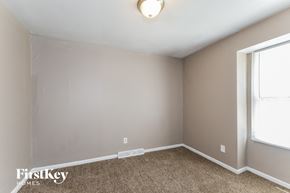 Saint Louis house for rent - a bedroom with a carpeted floor and a window