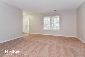 Indianapolis house for rent - a spacious living room with carpet and a window