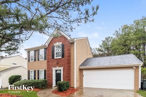Austell house for rent - A house with a red brick facade and a white garage door is for sale.