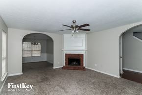 Austell house for rent - A living room with a fireplace and a ceiling fan.