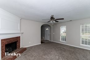 Austell house for rent - A spacious room with a fireplace and a ceiling fan.