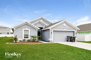 Poinciana house for rent - a blue house with a lawn and a driveway