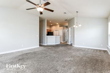 Poinciana house for rent - a living room with carpet and a ceiling fan