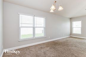 Poinciana house for rent - a bedroom with two windows and a carpeted floor