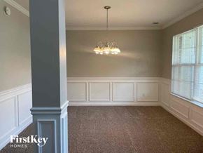 Hampton house for rent - a dining room with white wainscoting and a chandelier