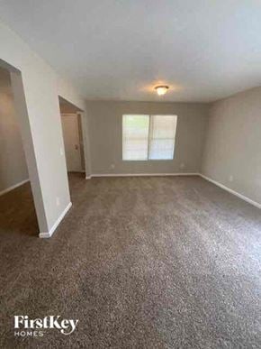 Covington house for rent - an empty living room with carpet and a window