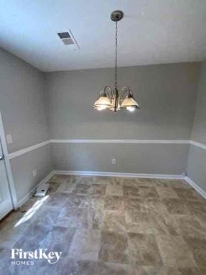 Covington house for rent - a empty room with a chandelier and a wooden floor