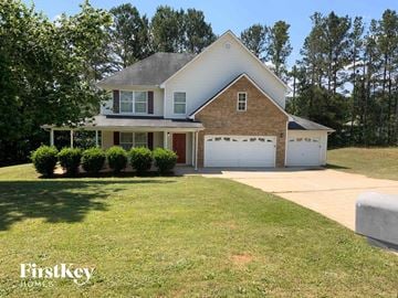Covington house for rent - a brick house with a lawn and a white garage door
