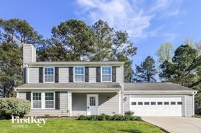 Alpharetta house for rent - a white house with a white garage door and a lawn