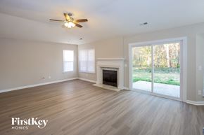 Charlotte house for rent - a living room with a fireplace and a ceiling fan