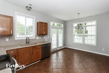 Cornelius house for rent - A kitchen with brown cabinets and a black dishwasher.
