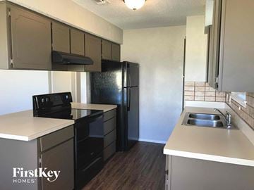 Crowley house for rent - an empty kitchen with black appliances and white counters