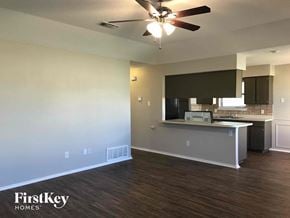 Crowley house for rent - an empty living room and kitchen with a ceiling fan