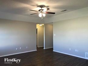 Crowley house for rent - an empty living room with a ceiling fan and white walls