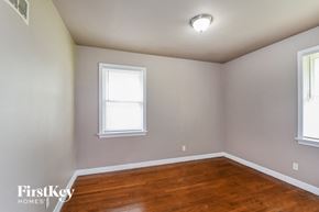Saint Louis house for rent - a bedroom with a wood floor and two windows
