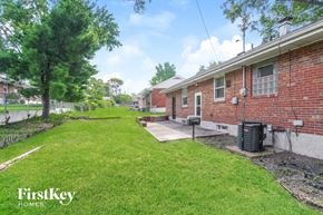 Saint Louis house for rent - the backyard of a brick house with a yard and grass
