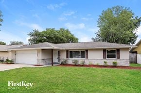 Deltona house for rent - A house with a well-maintained lawn and a clear sky above.